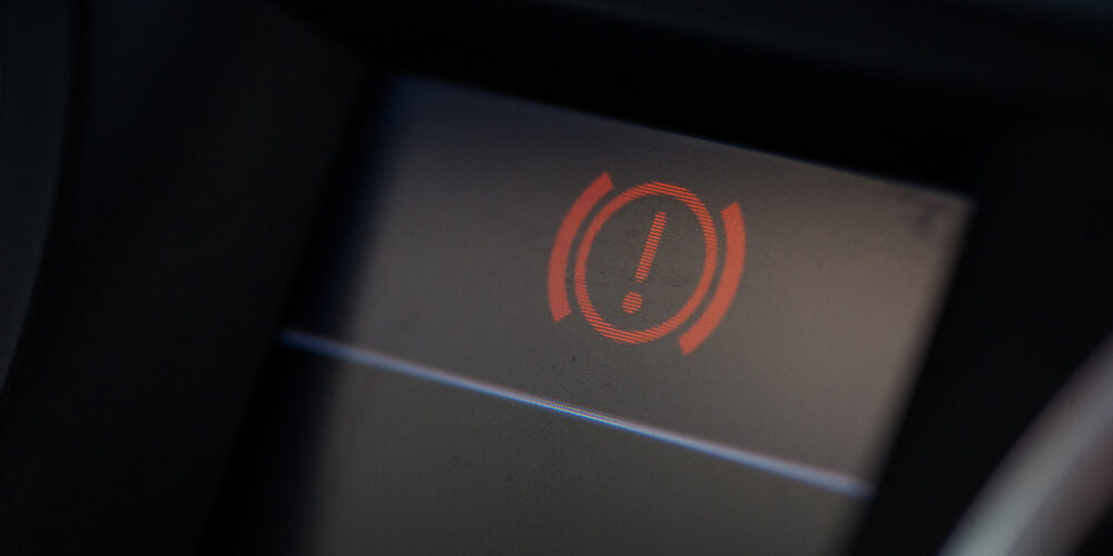 Image of a car's dashboard displaying parking light alert icon.